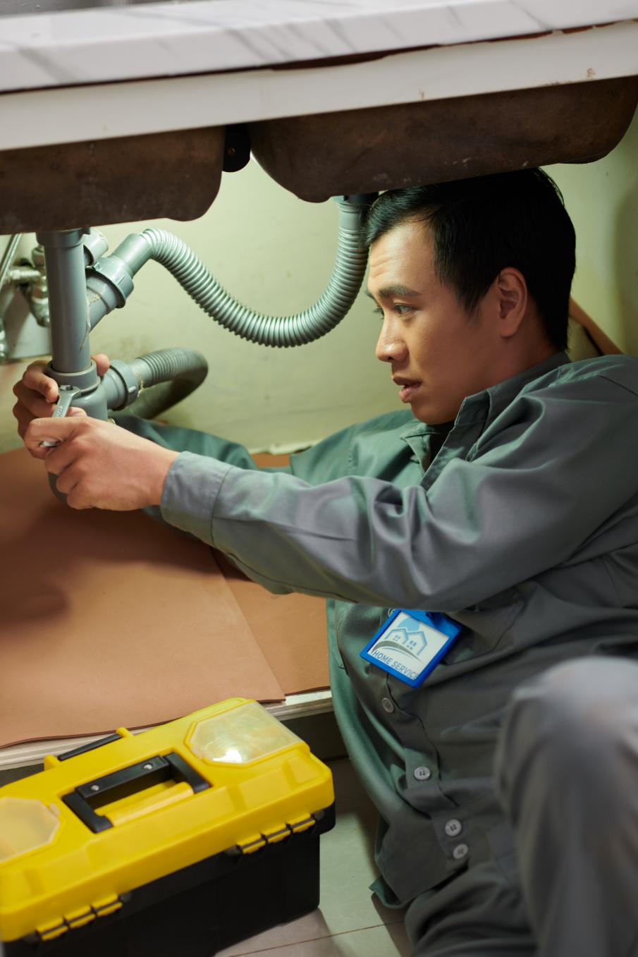 Professional plumber working on sink