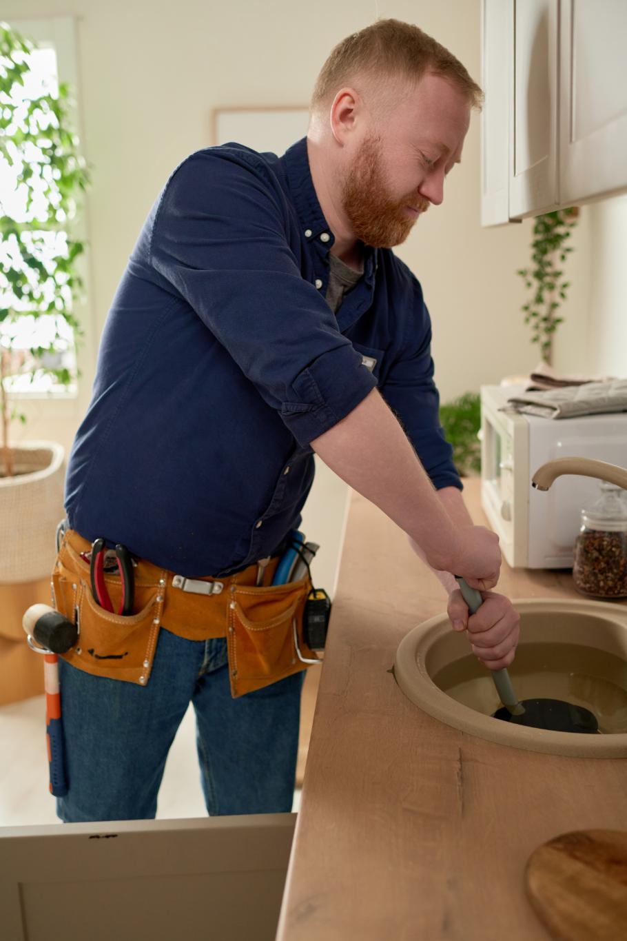 Worker repairing sink blockage